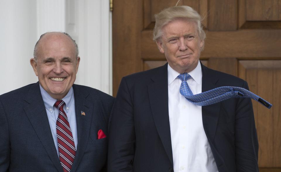 In this file photo taken on November 20, 2016, then President-elect Donald Trump meets with former New York City Mayor Rudy Giuliani at the clubhouse of the Trump National Golf Club in Bedminster, New Jersey.