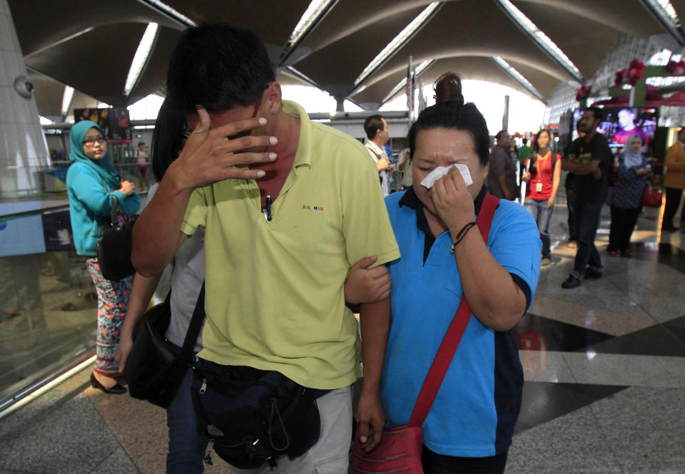 A woman wipes her tears after walking out of the reception center and holding area for family and friend of passengers aboard a missing Malaysia Airlines plane, at Kuala Lumpur International Airport in Sepang, outside Kuala Lumpur, Malaysia, Saturday, March 8, 2014. Search teams across Southeast Asia scrambled on Saturday to find a Malaysia Airlines Boeing 777 with 239 people on board that disappeared from air traffic control screens over waters between Malaysia and Vietnam early that morning. (AP Photo/Lai Seng Sin)