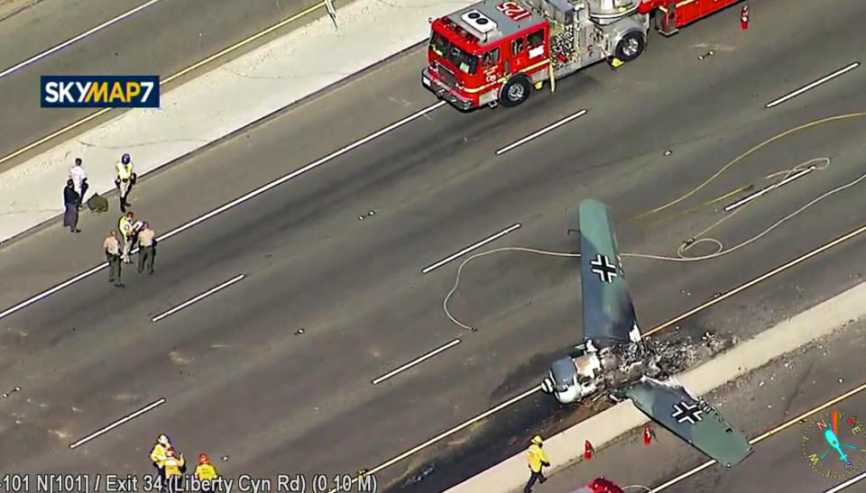 This photo taken from video provided by KABC-TV shows a vintage North American AT-6 airplane that crashed on U.S. 101 in Agoura Hills, Calif., Tuesday, Oct. 23, 2018. The pilot escaped uninjured and no one on the ground was hurt. The crash snarled traffic about 30 miles (50 kilometers) west of downtown Los Angeles. (KABC-TV via AP)