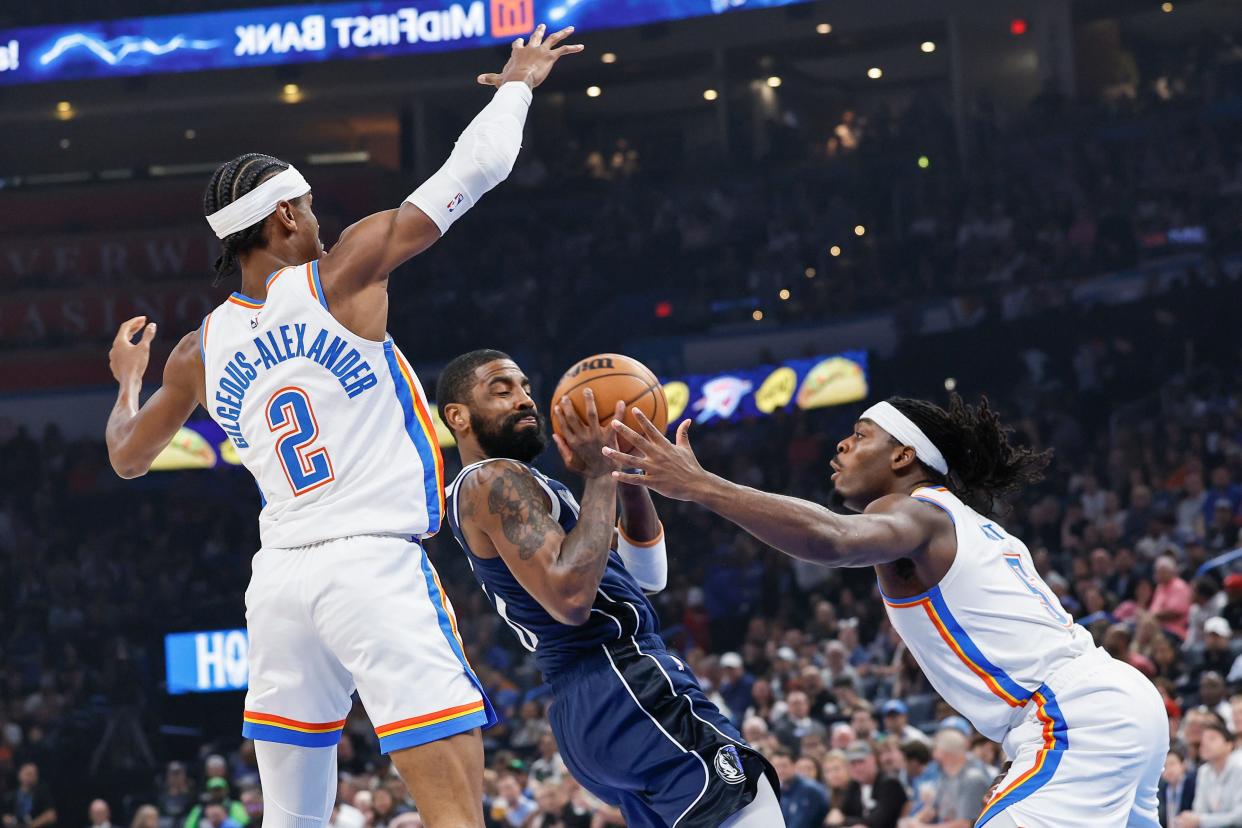 Thunder guard Luguentz Dort (5) defends a drive by Mavericks guard Kyrie Irving (11) during the first quarter at Paycom Center on March 14.