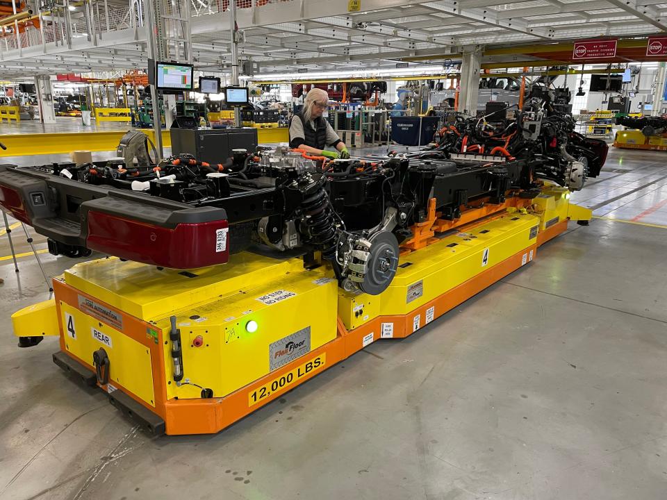 An assembly worker takes over after a robot did work on an F-150 Lightning.