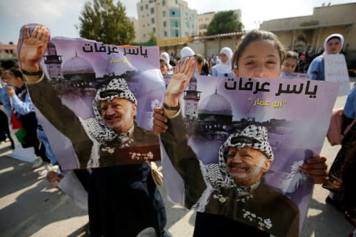 A girl holds a portrait of late leader Yasser Arafat as Palestinians mark the 14th anniversary of his death in the West Bank city of Ramallah on November 11, 2018