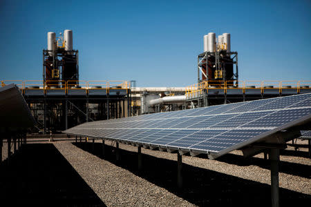 FILE PHOTO: Solar panels are seen in front of a natural gas power plant at the Tahoe-Reno Industrial Center in McCarran, Nevada, U.S., September 16, 2014. REUTERS/Max Whittaker/File Photo