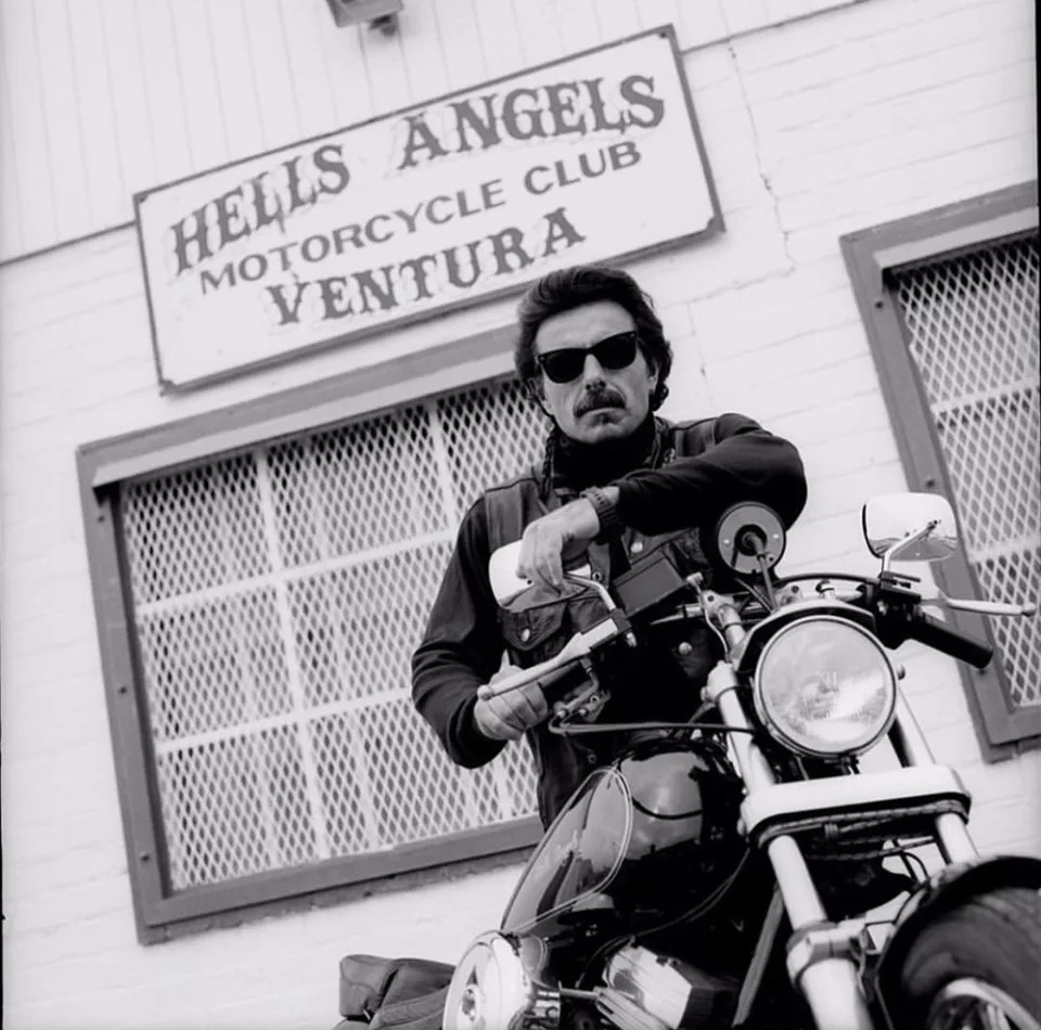 George Christie sitting on a motorcycle posing in front of the Hells Angels Motorcycle Club in Ventura