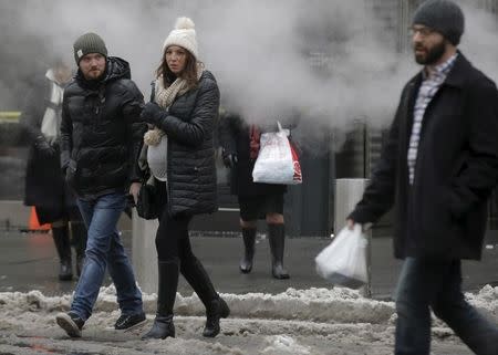 People cross a slush and snow covered street in lower Manhattan in New York January 25, 2016. REUTERS/Brendan McDermid