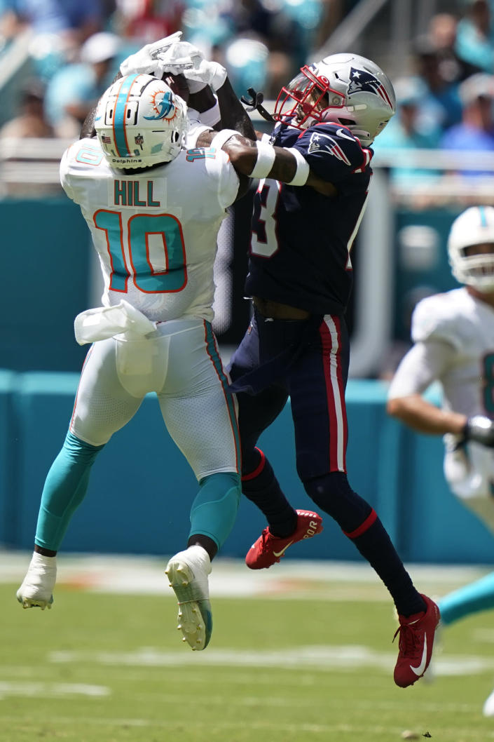 Miami Dolphins wide receiver Tyreek Hill (10) grabs a pass over New England Patriots defensive back Jack Jones (13 ) during the first half of an NFL football game, Sunday, Sept. 11, 2022, in Miami Gardens, Fla. (AP Photo/Lynne Sladky)