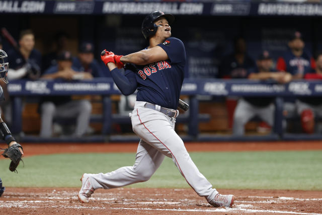 Boston Red Sox's Rafael Devers (11) is congratulated by Kiki Hernandez at  home plate after hitting a solo home run against the Kansas City Royals in  the eighth inning of a baseball