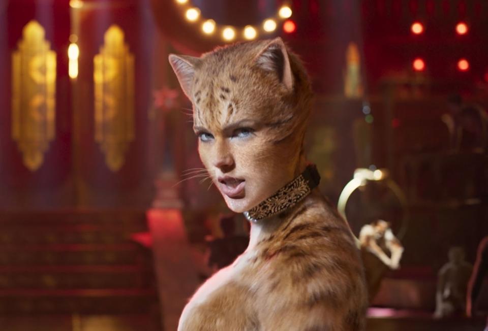 Scene from 'Cats' with CGI-animated humanoid cat characters in a theatrical setting