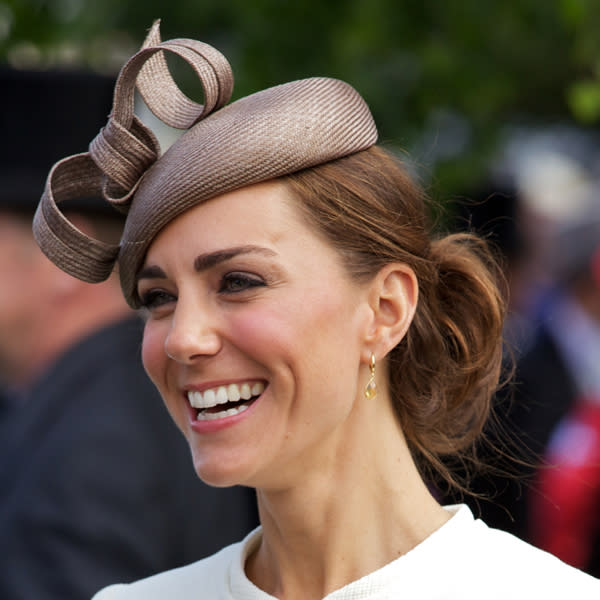 Kate Middleton Top 10 Best Hairstyles: The Duchess let her fascinator be the focus of her outfit by pulling her hair back in a loosely curled bun in June ©Rex