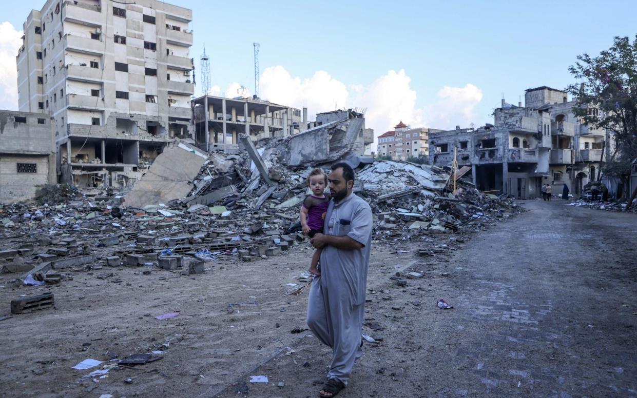 A Palestinian man walks amid the rubble of buildings destroyed during Israeli air strikes near his home in the Rafah refugee camp in the southern of Gaza Strip, on October 16