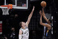 Milwaukee Bucks center Brook Lopez (11) defends as Brooklyn Nets forward Kevin Durant (7) shoots during the first half of Game 5 of a second-round NBA basketball playoff series Tuesday, June 15, 2021, in New York. (AP Photo/Kathy Willens)