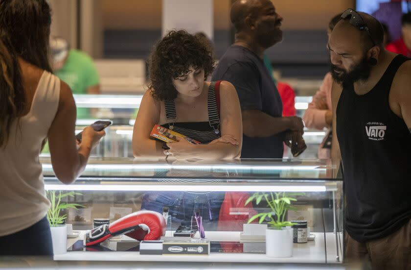 SANTA ANA, CA - July 21: Patrons view Tyson Ranch brand of cannabis products on display as former heavyweight champion and cannabis entrepreneur Mike Tyson signs autographs and takes photos with fans while promoting his Tyson Ranch brand at Planet 13 dispensary in Santa Ana on Wednesday, July 21, 2021. (Allen J. Schaben / Los Angeles Times)