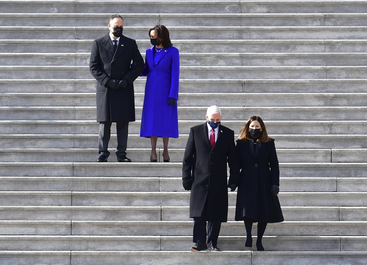 FILE - In this Jan. 20, 2021, file photo, Vice President Kamala Harris and her husband Doug Emhoff, top, watch as former Vice President Mike Pence and his wife Karen walk down the steps of the Capitol during the inauguration of President Joe Biden in Washington. Pence is steadily re-entering public life as he eyes a potential run for the White House in 2024. He's writing op-eds, delivering speeches, preparing trips to early voting states and launching an advocacy group likely to focus on promoting the accomplishments of the Trump administration. (David Tulis/Pool Photo via AP)