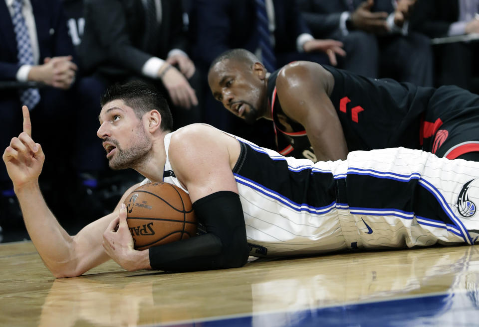 Orlando Magic's Nikola Vucevic, left, points upward after grabbing the ball away from Toronto Raptors' Serge Ibaka, right, and calling a timeout during the second half in Game 3 of a first-round NBA basketball playoff series, Friday, April 19, 2019, in Orlando, Fla. (AP Photo/John Raoux)