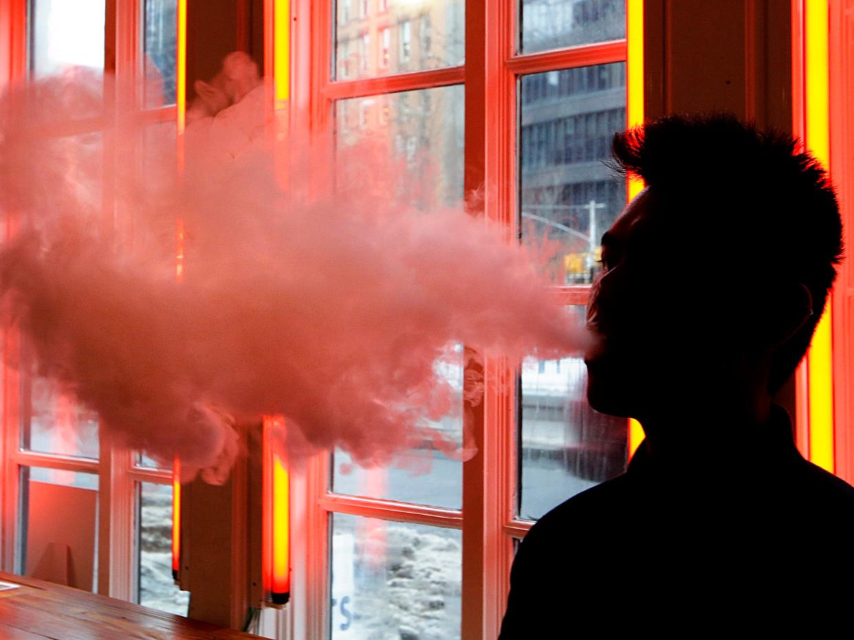 FILE - In this Feb. 20, 2014, file photo, a patron exhales vapor from an e-cigarette at a store in New York. Only two years ago e-cigarettes were viewed as holding great potential for public health: offering a way to wean smokers off traditional cigarettes. But now Juul and other vaping companies face an escalating backlash that threatens to sweep their products off the market. (AP Photo/Frank Franklin II, File)