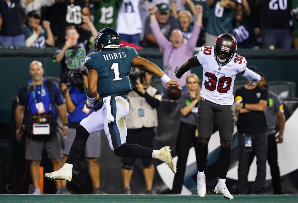 Philadelphia Eagles quarterback Jalen Hurts (1) scores a touchdown in front of Tampa Bay Buccaneers defensive back Dee Delaney (30) during the second half of an NFL football game Thursday, Oct. 14, 2021, in Philadelphia. (AP Photo/Matt Rourke)