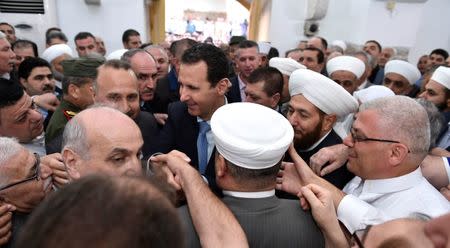 Syria's President Bashar al-Assad greets his supporters during Eid al-Fitr prayers at a mosque in Hama, in this handout picture provided by SANA on June 25, 2017, Syria. SANA/Handout via REUTERS