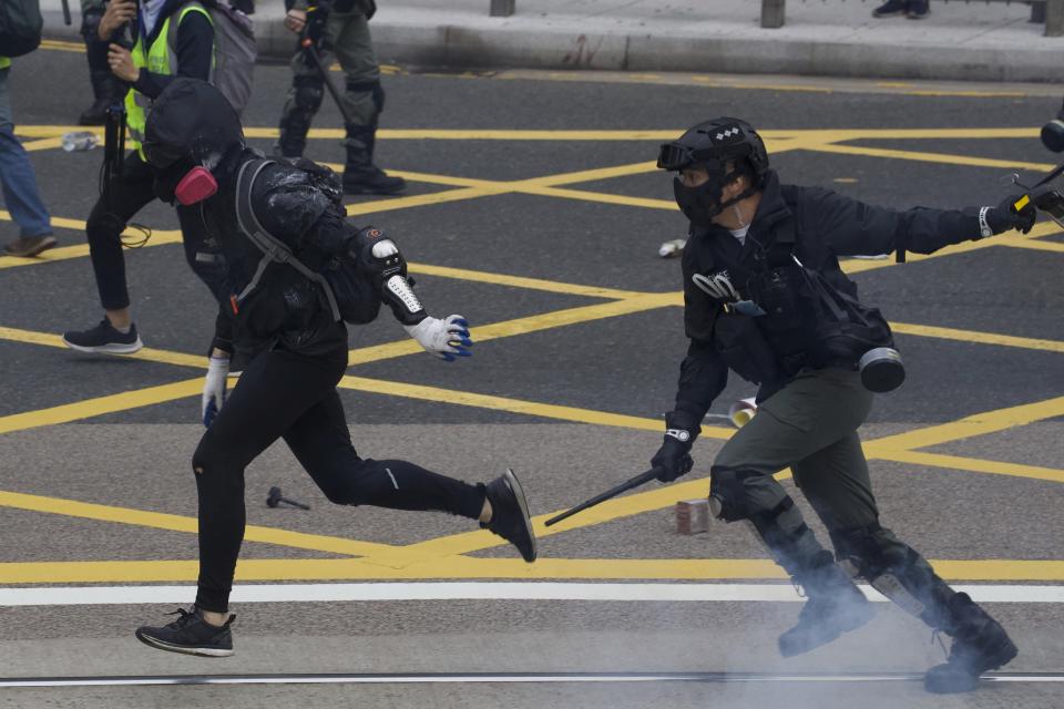 Riot police clash with protesters calling for electoral reforms and a boycott of the Chinese Communist Party in Hong Kong, Sunday, Jan. 19, 2020. Hong Kong has been wracked by often violent anti-government protests since June, although they have diminished considerably in scale following a landslide win by opposition candidates in races for district councilors late last year. (AP Photo/Ng Han Guan)