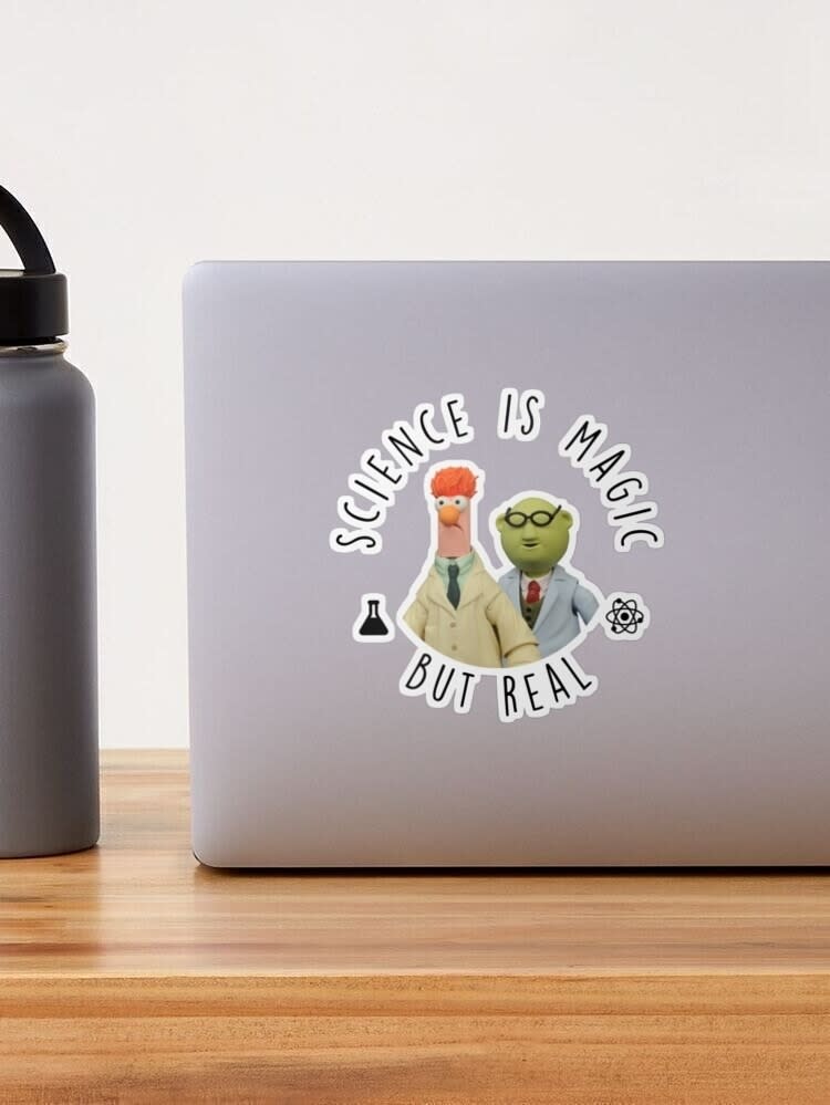 Laptop with a sticker of the Muppets' Beaker and Dr. Bunsen with text "Science is magic but real."