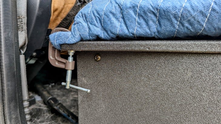 <span class="article__caption">The memory foam mattress topper and moving blanket cover the entire surface of the cargo plate, turning the entire thing into a spacious, unified dog bed. C-clamps keep it all in place as the dogs move around. </span>