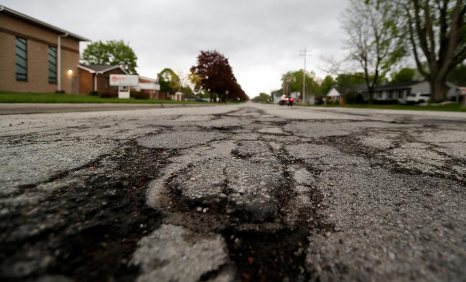 Potholes are seen on Bond Street near North Taylor Street on May 20, 2022, in Green Bay.