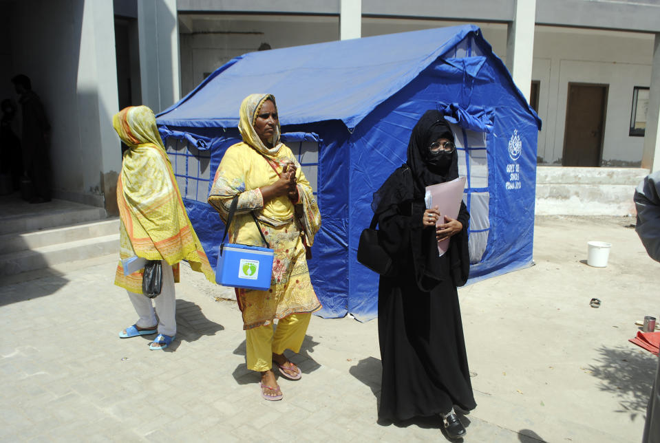 Health workers go door to door dispensing vaccinations for flood victims from monsoon rains at a camp in Hyderabad, Pakistan, Tuesday, Sept. 6, 2022. In flood-stricken Pakistan where an unprecedented monsoon season has already killed hundreds of people, the rains are now threatening an ancient archeological site dating back 4,500 years, the site's chief official said Tuesday. (AP Photo/Pervez Masih)