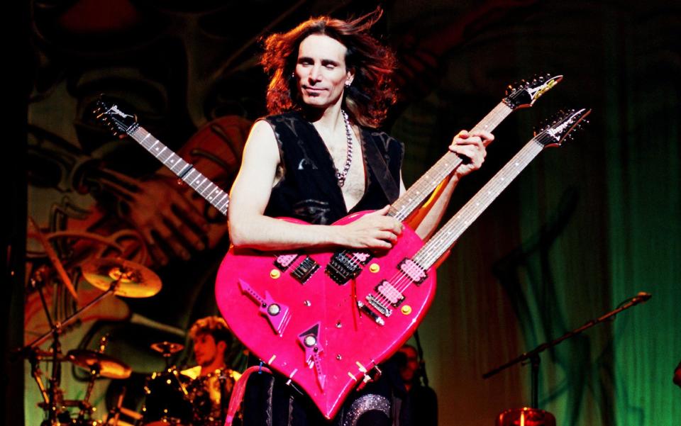 Vai performing in 2000 with his trademark pink guitar - Alamy