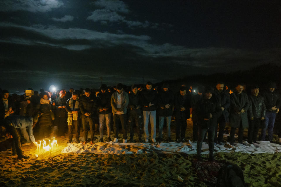 Survivors and relatives of the victims pray, Monday, Feb. 26, 2024, at the site where a migrant boat capsized in the early morning of Sunday, Feb. 26, 2023, at a short distance from the shore in Steccato di Cutro, in the Italian southern tip, killing at least 94 people. Survivors and family members of the victims gathered at the same time on the day of the disaster for a commemoration on the first anniversary. (AP Photo/Valeria Ferraro)