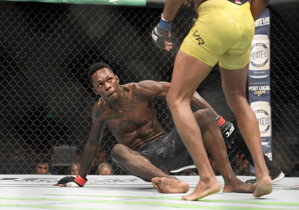 Nigeria's Israel Adesanya falls as he plays Brazil's Anderson Silva in their middleweight bout at the UFC 234 event in Melbourne, Australia, Sunday, Feb. 10, 2019. (AP Photo/Andy Brownbill)