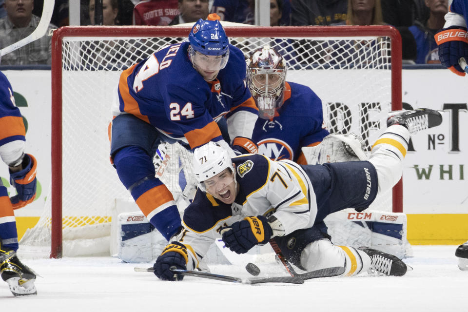 New York Islanders defenseman Scott Mayfield (24) holds down Buffalo Sabres left wing Evan Rodrigues (71) in the second period of an NHL hockey game, Saturday, Dec. 14, 2019 in Uniondale, N.Y. (AP Photo/Mark Lennihan)