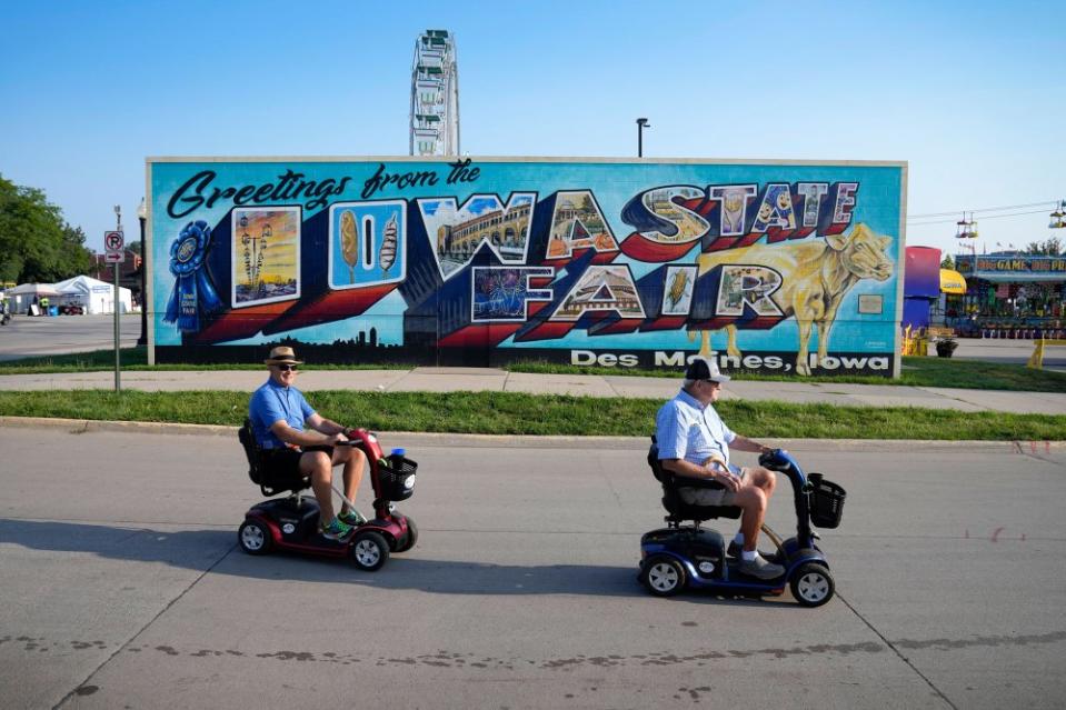 Two men make their way across the fairgrounds during the opening day of the Iowa State Fair, on Aug. 10.<span class="copyright">Charlie Neibergall—AP</span>