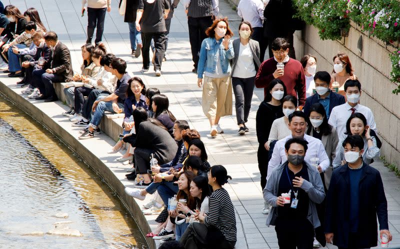 FILE PHOTO: FILE PHOTO: People wear masks to prevent the spread of the coronavirus disease (COVID-19) as they take a walk on a sunny spring day in Seoul