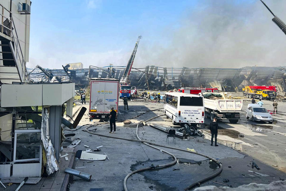 Firefighters work to extinguish a fire at a site of a warehouse in Tashkent, Uzbekistan. An an explosion in the Uzbek capital of Tashkent has killed a teenage boy and injured at least 163 people according to Uzbekistan's Ministry of Health which said a fire broke out after a lightning strike. (Daryo news agency via AP)