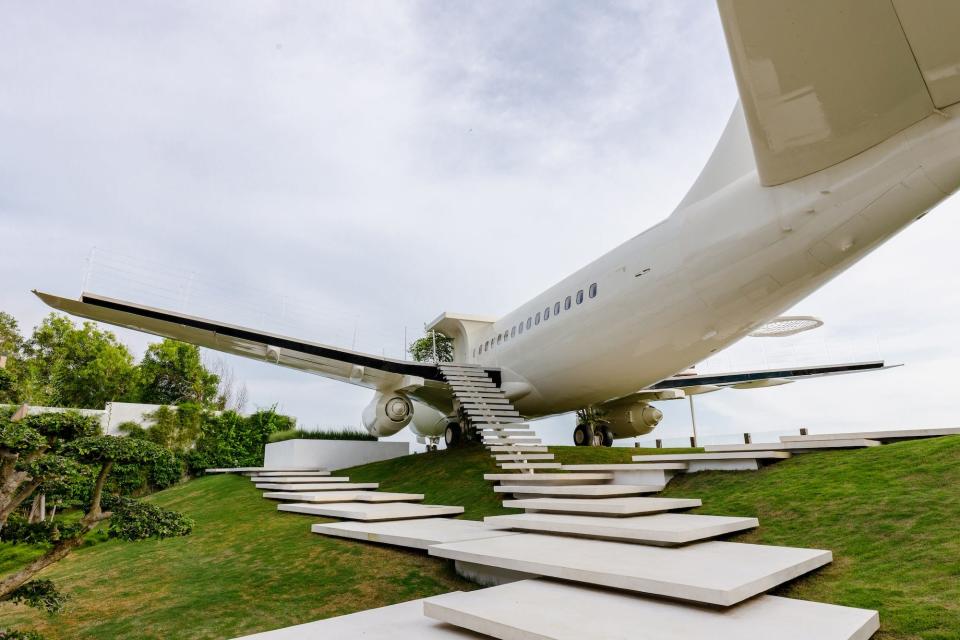 Stone steps lead ip to a white plane in front of a cloudy backdrop.