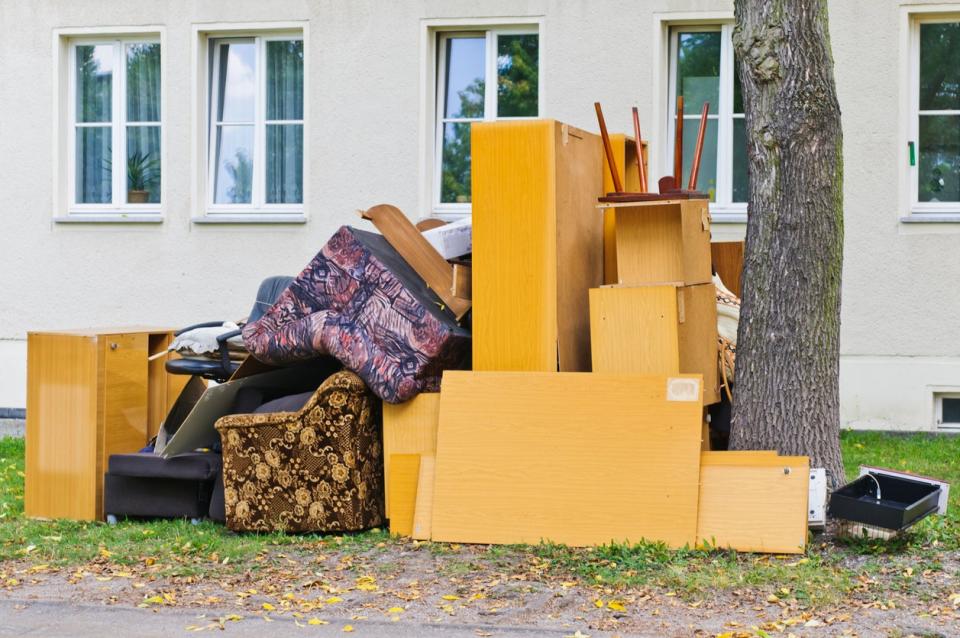 A home's curbside filled with second hand furniture. 