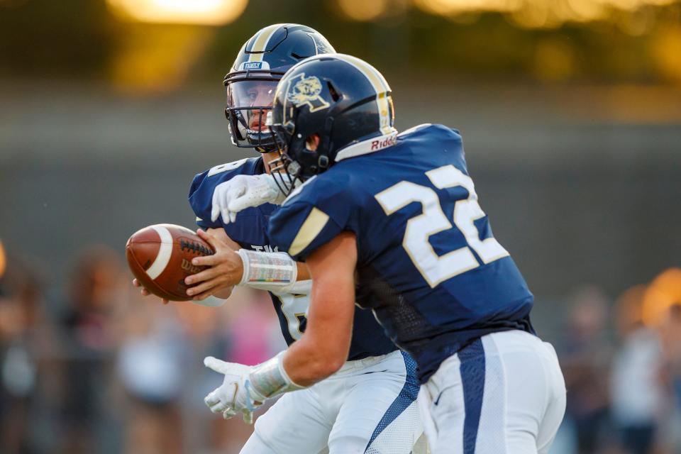 Grant Buchanan (8) of Arlington hands the ball off to Jackson Hair (22) of Arlington against MUS  during the game between the Arlington Tigers and MUS Owls on Friday August, 19th 2022 in Arlington, Tn (Justin Ford/Special to the Commercial Appeal)