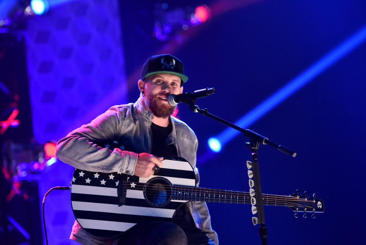 Brantley Gilbert poses for the camera while performing on stage and he looks breath