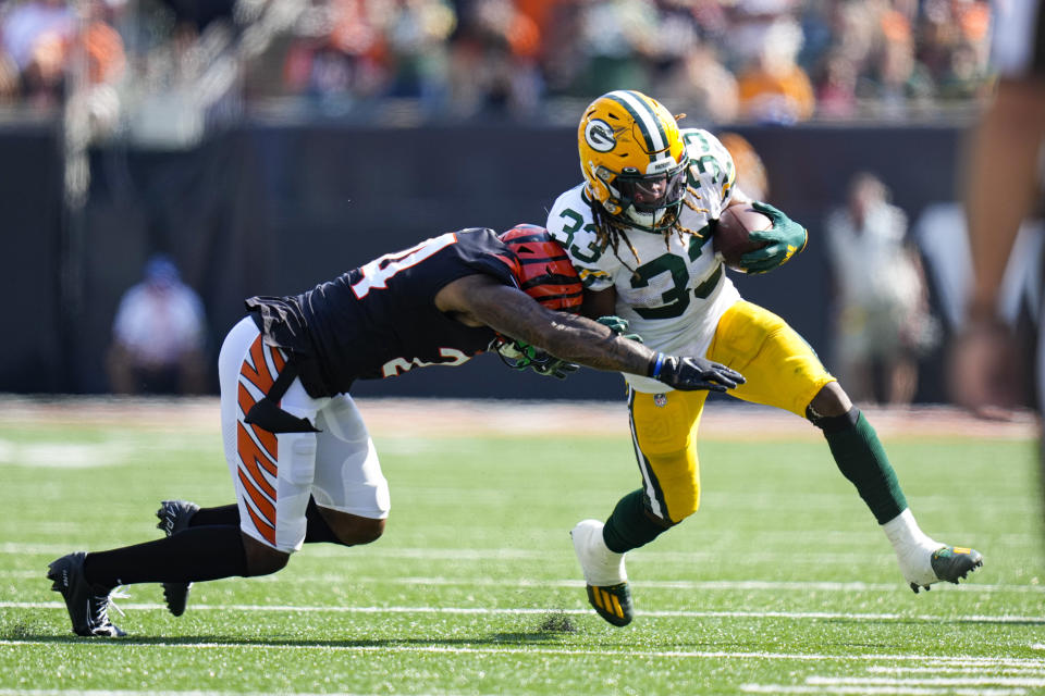 Green Bay Packers running back Aaron Jones (33) is pushed out-of-bounds by Cincinnati Bengals safety Vonn Bell (24) in the first half of an NFL football game in Cincinnati, Sunday, Oct. 10, 2021. (AP Photo/AJ Mast)