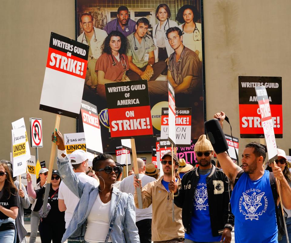 Members of the Writers Guild of America picket in front of Warner Brothers Studio in Burbank, Calif. The strike comes after weeks of negotiations failed to generate a contract between the guild and the Alliance of Motion Picture and Television Producers (AMPTP), which bargains on behalf of the nine largest studios. The WGA represents most writers for film and TV in the U.S.