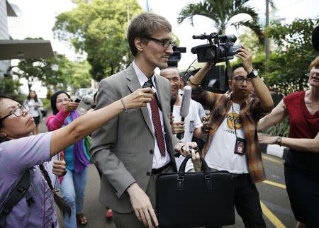 An unidentified French government representative (C) is surrounded by the media as he leaves the Foreign Minister office after a meeting with Indonesian officials in Jakarta, February 16, 2015. REUTERS/Beawiharta