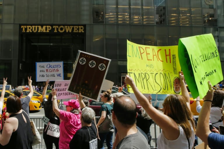 People shout slogans against US president Donald Trump as they march in front of Trump Tower in New York City