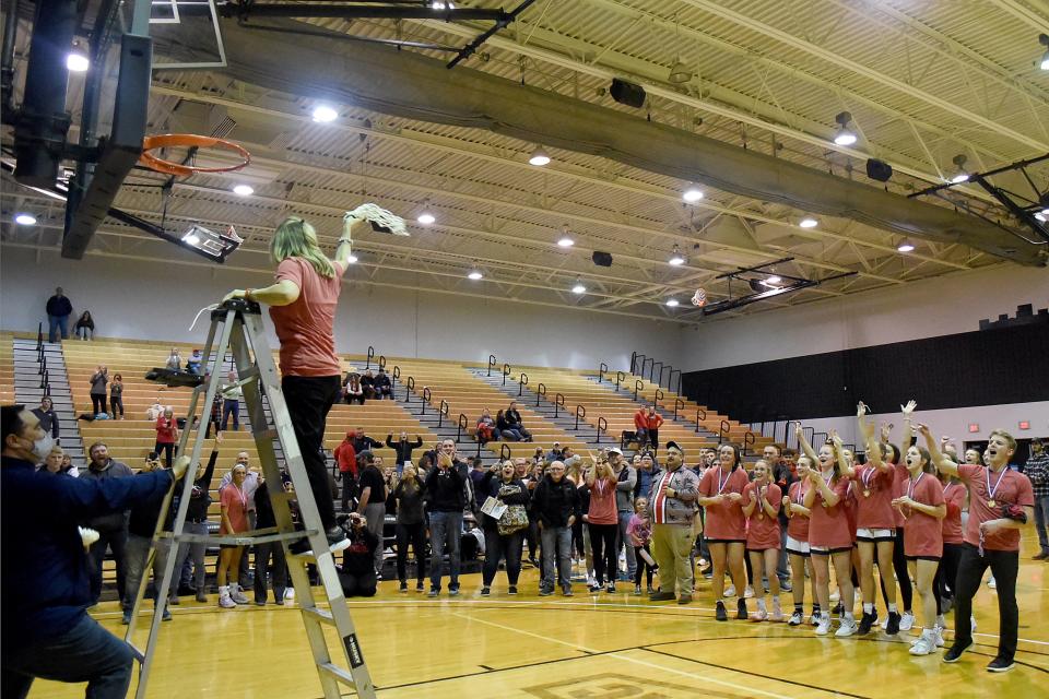 Pleasant head coach Keriann Pratt waves to net to the crowd and her team after the Spartans won the Division III district championship in girls basketball at Ohio Dominican's Alumni Hall.
