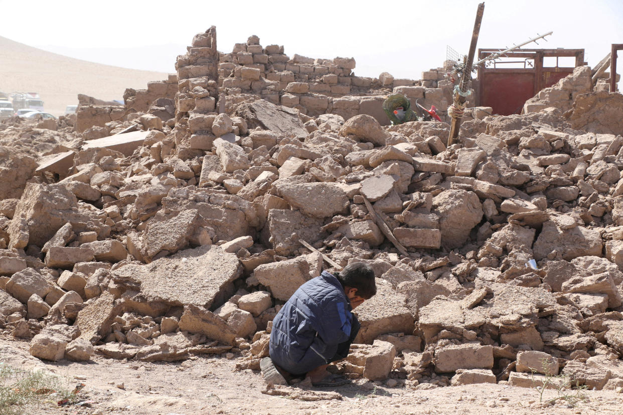 A boy cries as he sits next to debris in the aftermath of an earthquake.