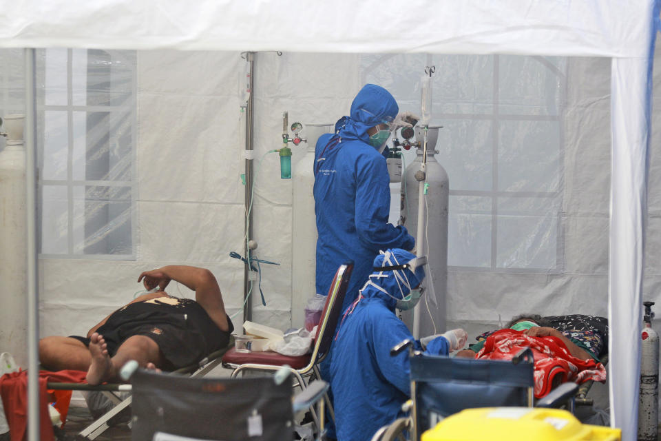 Medical workers treat patients inside an emergency tent erected to accommodate a surge in COVID-19 cases, at Dr. Sardjito Central Hospital in Yogyakarta, Indonesia, Sunday, July 4, 2021. A number of COVID-19 patients died amid an oxygen shortage at the hospital on the main island of Java following a nationwide surge of coronavirus infections. (AP Photo/Kalandra)