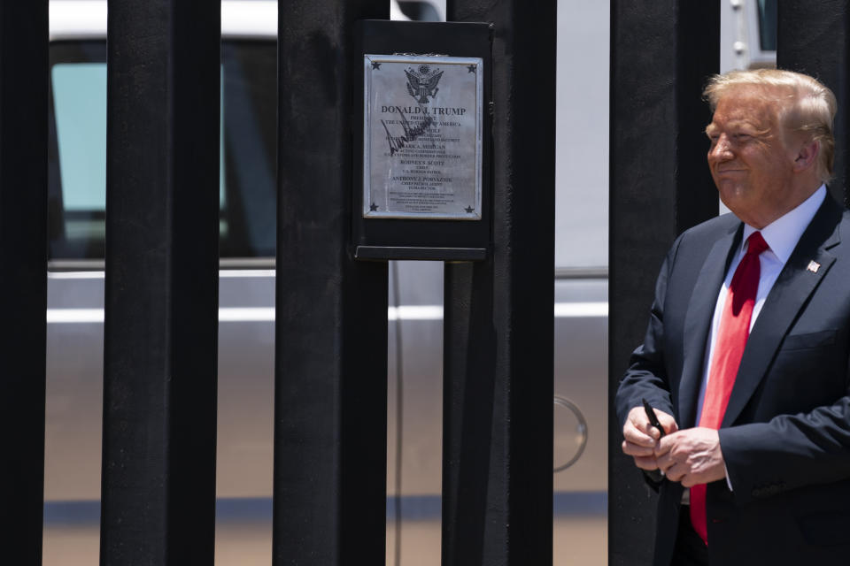 FILE - In this June 23, 2020, file photo President Donald Trump smiles after autographing a section of the border wall during a tour in San Luis, Ariz. The Trump administration sought to halt migrants from crossing the southwest border through measures that included forcing people seeking asylum to do to so in Mexico or Central America and building about 450 miles of wall. (AP Photo/Evan Vucci, File)