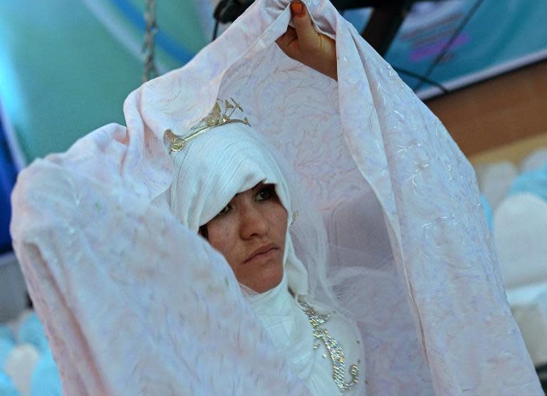 An Afghan bride looks on during a mass wedding ceremony in which 100 couples were married near Kabul, October 10, 2014