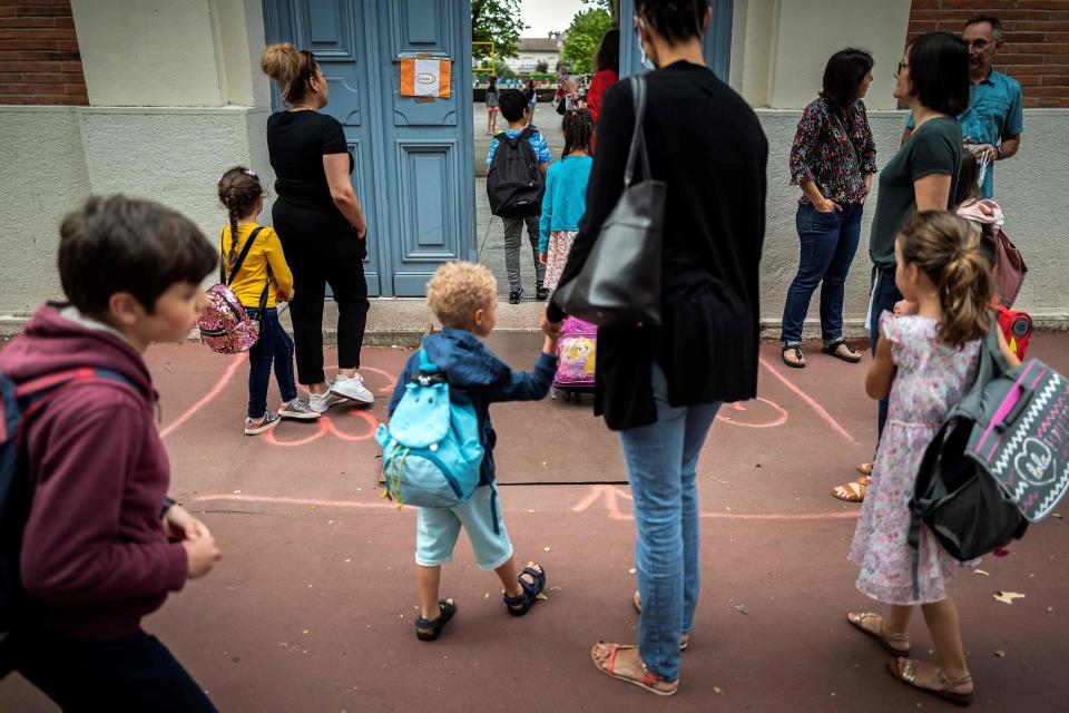 Image: Parents and children arrive at the Jules Julien elementary school in Toulouse, southern France, on June 22, 2020 following the reopening of schools (Lionel Bonaventure / AFP - Getty Images)