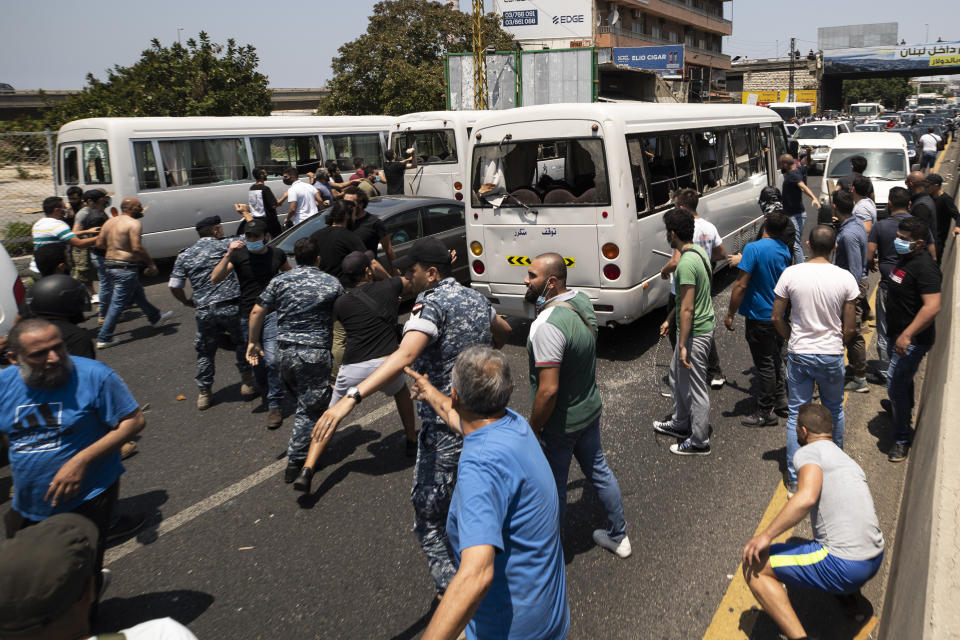 Members of the Christian rightwing Lebanese Forces group attack buses carrying Syrian voters heading to their embassy to vote in the Syrian presidential election, in the town of Zouk Mosbeh, north of Beirut, Lebanon, Thursday, May 20, 2021. Mobs of angry Lebanese men attacked vehicles carrying Syrians expatriates and those who fled the war heading to the Syrian embassy in Beirut on Thursday, protesting against what they said was an organized vote for President Bashar Assad. (AP Photo/Hassan Ammar)