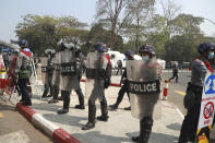 Police with shield stand in formation during a demonstration against the military coup in Yangon, Myanmar, Friday, Feb. 26, 2021. Security forces in Myanmar’s largest city of Yangon have fired warning shots and beat truncheons against their shields while moving to disperse more than 1,000 anti-coup protesters. (AP Photo)