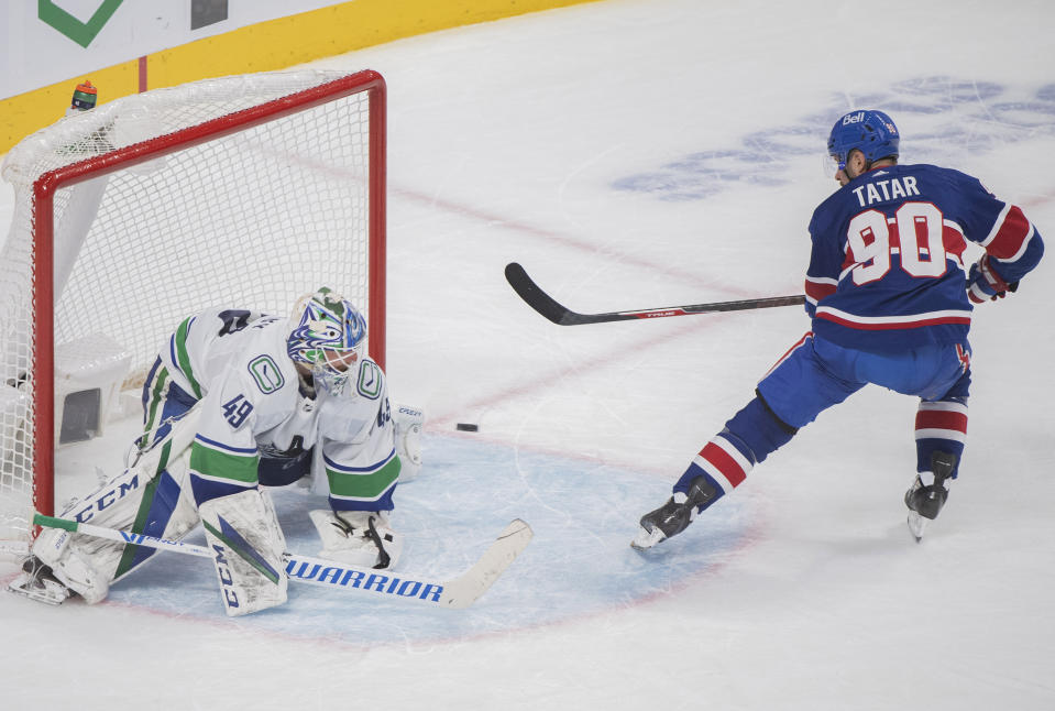 Montreal Canadiens' Tomas Tatar scores against Vancouver Canucks goaltender Braden Holtby during the shootout in an NHL hockey game Saturday, March 20, 2021, in Montreal. (Graham Hughes/The Canadian Press via AP)